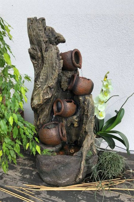 🌿 نافورة الجرار الفخارية على جذع الشجرة